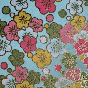 Origami paper, Chiyogami  paper, Yuzen paper, Washi paper.  Pink, yellow, green on blue sakura cherry blossom pattern with gold accents.
