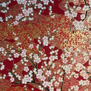 May include: A vibrant red background with a gold and white floral pattern. The design features stylized branches with white blossoms and gold accents, creating a rich, textured look. The overall theme is a Japanese-inspired floral design.