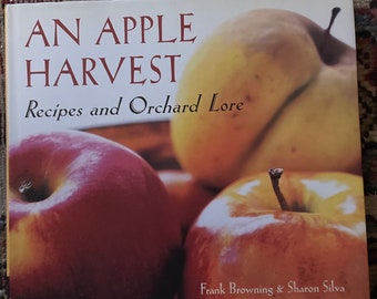 May include: A cookbook titled "An Apple Harvest: Recipes and Orchard Lore" with a photo of red and yellow apples on the cover.