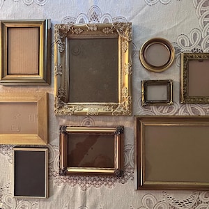 May include: A collection of antique picture frames in various shapes and sizes. The frames are gold, silver, and brown, with ornate and simple designs. Some frames are rectangular, square, and oval, and are empty.