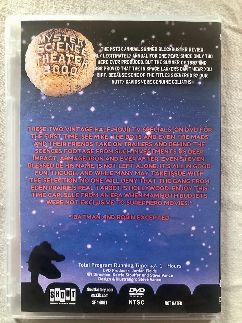 以下が含まれることがあります： ミステリー・サイエンス・シアター3000のDVDケース。青と白の星がついた月の画像が描かれている。ケースのテキストには「ミステリー・サイエンス・シアター3000」と「The MST3K Annual Summer Blockbuster Review」と書かれている。