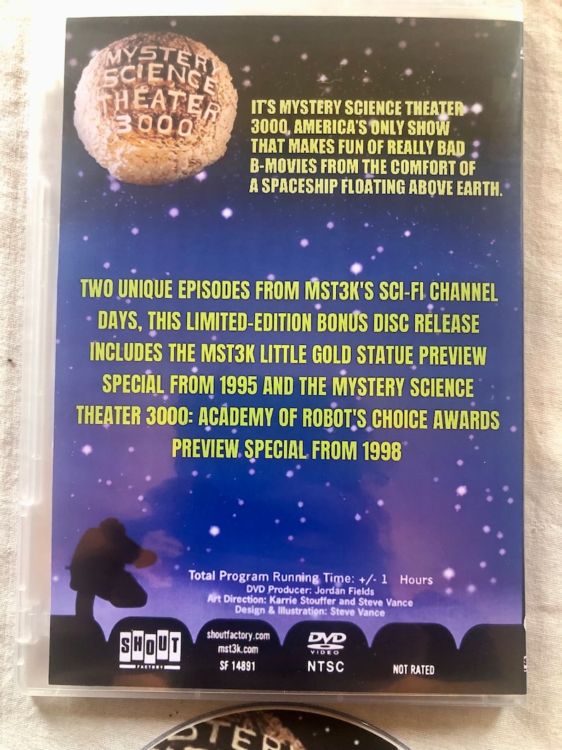 K&ouml;nnte beinhalten: DVD-H&uuml;lle f&uuml;r Mystery Science Theater 3000 mit blauem Hintergrund, einem wei&szlig;en Raumschiff und Sternen. Die H&uuml;lle enth&auml;lt den Text "Mystery Science Theater 3000" und "Es ist Mystery Science Theater 3000, die einzige amerikanische Show, die sich &uuml;ber wirklich schlechte B-Filme lustig macht, aus dem Komfort eines Raumschiffs, das &uuml;ber der Erde schwebt." Die H&uuml;lle enth&auml;lt auch den Text "Zwei einzigartige Episoden aus MST3Ks Sci-Fi-Kanal Days, diese limitierte Bonus-Disc-Ver&ouml;ffentlichung enth&auml;lt die Vorschau der kleinen goldenen MST3K-Statue aus dem Jahr 1995 und die Vorschau-Spezialausgabe der Robot's Choice Awards von Mystery Science Theater 3000 aus dem Jahr 1998."