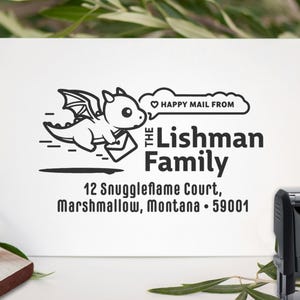 May include: A white address stamp featuring a cartoon dragon carrying mail, with the text "HAPPY MAIL FROM" above "The Lishman Family" and address details. A black stamp is visible on the right.