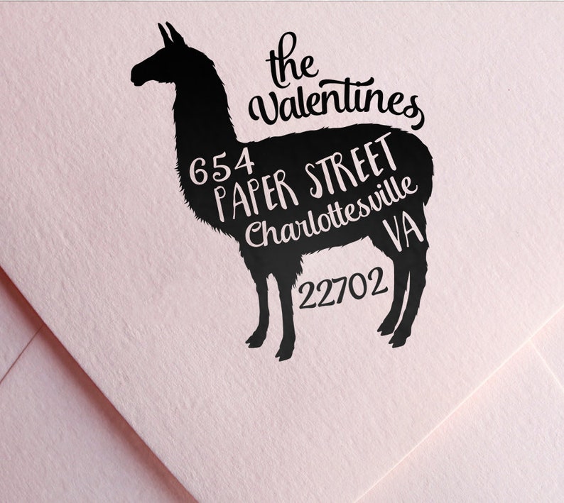 May include: Black silhouette of a llama with the text "the valentines" above it and "654 paper street charlottesville va 22702" inside the silhouette.