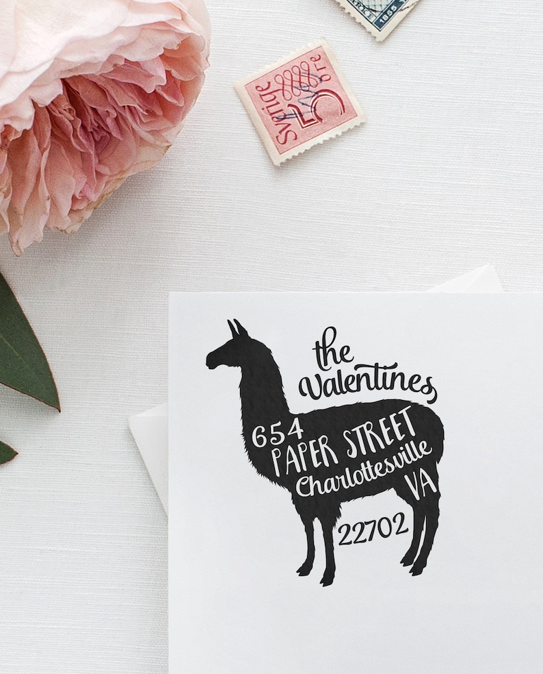 May include: Black silhouette of a llama with white text overlayed on the body. The text reads "the valentines 654 paper street charlottesville VA 22702".