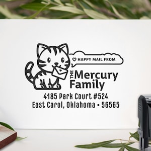 May include: A black and white address stamp featuring a cartoon cat holding an envelope. The stamp includes the text "Happy Mail From" above "The Mercury Family" and an address: 4185 Park Court #524, East Carol, Oklahoma, 56565.