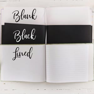 May include: Open notebook with three sections: blank, black lined, and lined. The notebook is white with black text.