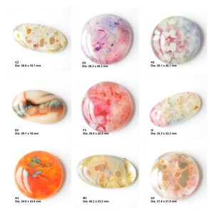 May include: Nine round and oval-shaped cabochons with various patterns and colors, including pink, white, brown, and orange. The cabochons are approximately 2 to 4 inches in diameter.