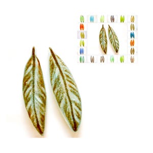 May include: Two ceramic leaf-shaped earrings in a light blue and brown glaze. The leaves have a detailed vein pattern.
