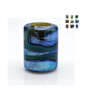 May include: A cylindrical glass bead with a blue, green, and gold marbled pattern. The bead has a smooth, glossy finish.