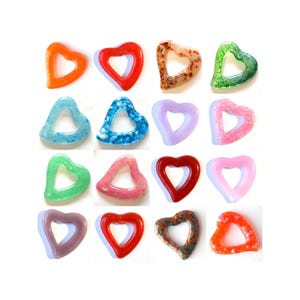 May include: Assortment of 16 heart-shaped glass charms in various colours, including red, orange, yellow, green, blue, purple, pink, and white. Each charm has a hole in the centre for hanging.