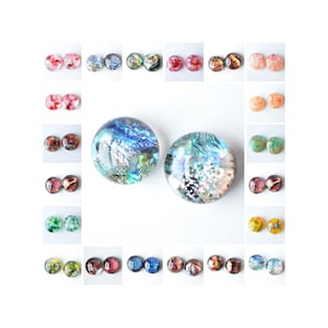 May include: Assortment of 20 round glass cabochons with various colourful patterns and designs. The cabochons are approximately 2.5 cm in diameter.