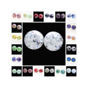 Op de afbeelding: Een set van 24 ronde glazen cabochons met verschillende kleurrijke patronen. De cabochons zijn ongeveer 2,5 cm in diameter en hebben een glanzende afwerking.