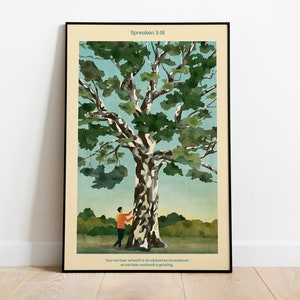 Op de afbeelding: Een ingelijste print met een aquarel-illustratie van een grote boom met een persoon ernaast. De tekst "Spreuken 3:18" staat bovenaan de print. De tekst onder de afbeelding luidt "Voor wie haar verworft is de veiligheid een levensboom en wie haar vast houdt is gelukkig."