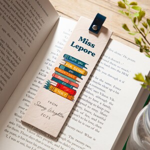 May include: A beige bookmark featuring a stack of colourful books with the text "Thank you for being an important part of my story". The bookmark also includes the text "Miss Lepore" and "From Sammy Wrighton 2023".