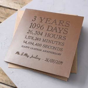 May include: A brown leather card with the text "3 YEARS 1096 DAYS 26,304 HOURS 1,578,240 MINUTES 94,694,400 SECONDS HAPPY LEATHER ANNIVERSARY Mr & Mrs Jenkins - 26/07/2014" embossed on it.
