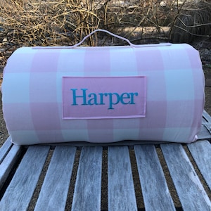 May include: Pink and white gingham patterned play mat with a handle and a personalized name tag that says "Harper".