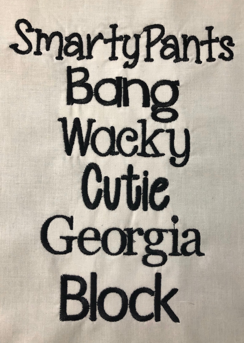 May include: Embroidered text on a white fabric background. The text reads "Smarty Pants Bang Wacky Cutie Georgia Block".