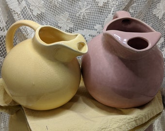 These two kitchen cousins can be yours! They are so sweet, unmarked art deco ball pitchers, one a sunny yellow and the other a subdued pink.