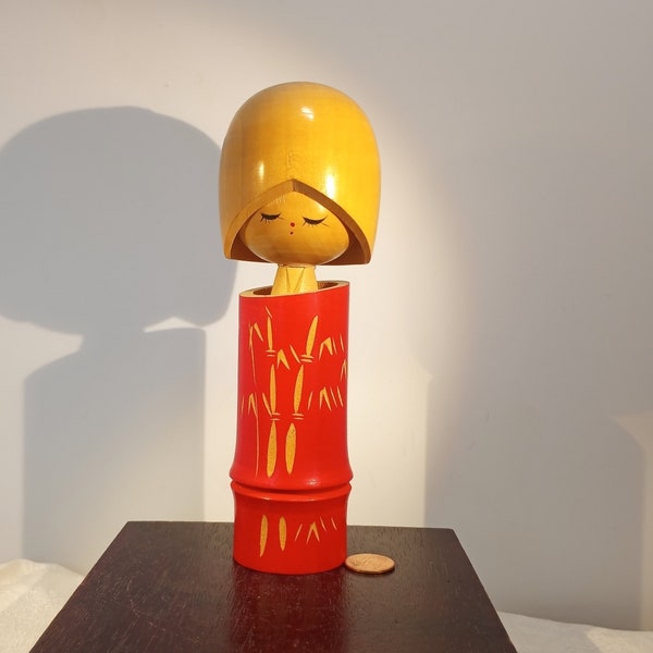 Un visage si tendre et de beaux cils, cette poupée Kokeshi en bambou rouge est bien faite avec une signature et des autocollants originaux.