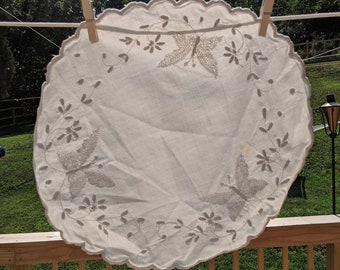 Butterflies and a whimsical vine of flowers and buds encircled with heavily embroidered scallops adorn this lovely 15&quot; across table cloth.