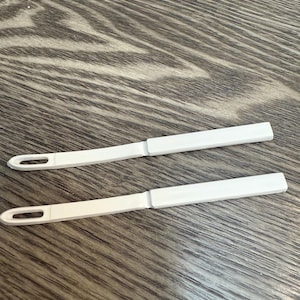 1 pair of white straight barrettes with teeth.