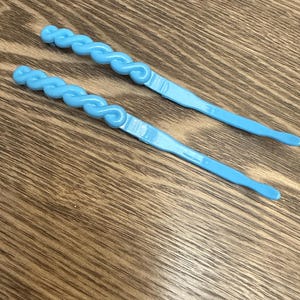1 pair of blue braided barrettes.