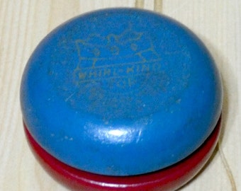May include: A blue and red yo-yo with a gold crown and the text "Whirl-King" on the top.