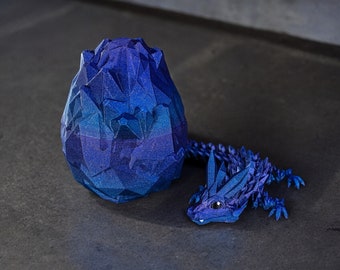 May include: A blue origami dragon with a blue origami egg. The dragon is curled around the egg.