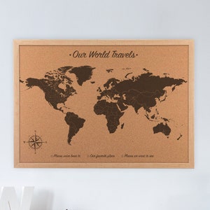 Our world travels world map cork board. This 23 x 17 inch cork world map is engraved directly on the cork board for a lifetime of travels and pinning your adventures. Hanging on the wall above a home office desk.