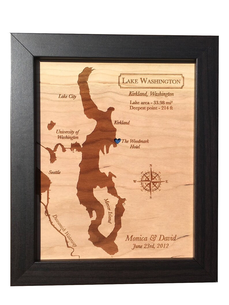May include: A wooden map of Lake Washington, Kirkland, Washington, with a blue pin marking the location of The Woodmark Hotel. The map includes the text "Lake Washington, Kirkland, Washington, Lake area - 33.98 mi&sup2;, Deepest point - 214 ft" and "Monica & David, June 23rd, 2012".