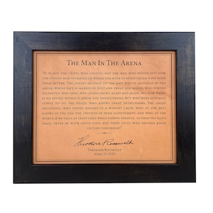 Theodore Roosevelts Man in the Arena quote laser-engraved on high-quality leather, designed as a premium luxury gift. Framed in a rich dark walnut frame, it  includes Theodore Roosevelts signature, making it a distinctive leather graduation gift.