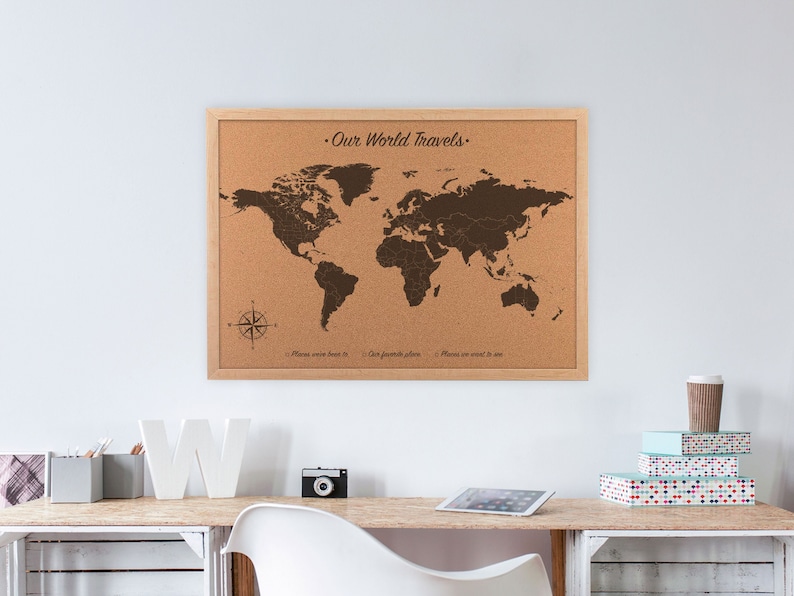 Our world travels world map cork board. This 23 x 17 inch cork world map is engraved directly on the cork board for a lifetime of travels and pinning your adventures. Hanging on the wall above a home office desk.