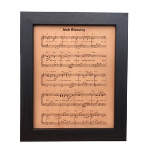 A framed, leather-engraved sheet music displaying the beloved Irish Blessing. Personalization option includes the couple's first names and wedding date, set in a dark walnut frame.