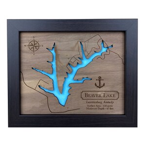 May include: A framed wooden map of Beaver Lake in Lawrenceburg, Kentucky. The lake is outlined in blue and the map includes a compass rose and an anchor. The text "Beaver Lake" is printed in a banner at the bottom of the map, along with the lake's surface area and maximum depth.