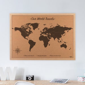 World travel map cork board with pins. This 23 x 17 inch cork world map is engraved directly on the cork board for a lifetime of travels and pinning your adventures. Personalized and made to order travel map gift. Hanging on wall in an office decor