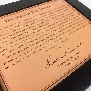 detailed view of the leather framed Man in the Arena engraved quote by Theodore Roosevelt.