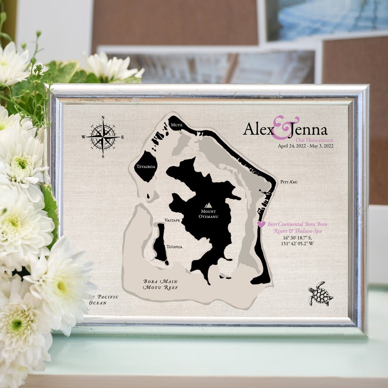 Cotton keepsake map is designed of Bora Bora and customized with wedding and honeymoon location, names and travel dates. Printed on cotton canvas for a 2nd wedding anniversary. Framed and sitting next to white flowers