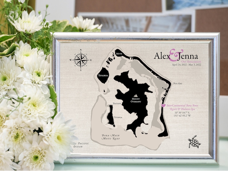 Cotton keepsake map is designed of Bora Bora and customized with wedding and honeymoon location, names and travel dates. Printed on cotton canvas for a 2nd wedding anniversary. Framed and sitting next to white flowers