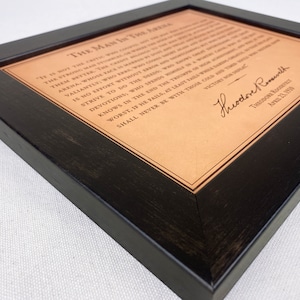 detailed view of the leather framed Man in the Arena engraved quote by Theodore Roosevelt.