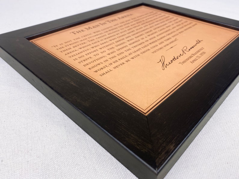 detailed view of the leather framed Man in the Arena engraved quote by Theodore Roosevelt.