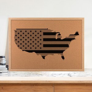 May include: A corkboard with a black and white outline of the United States of America in the shape of a flag.