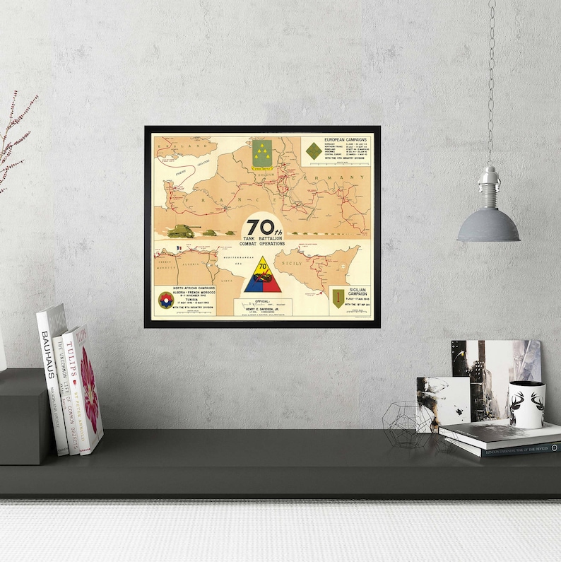 May include: A framed map showing the combat operations of the 70th Tank Battalion during World War II. The map shows the battalion's movements in Europe, including the North African Campaign, the Sicilian Campaign, and the Italian Campaign. The map is in a black frame and has a white background.