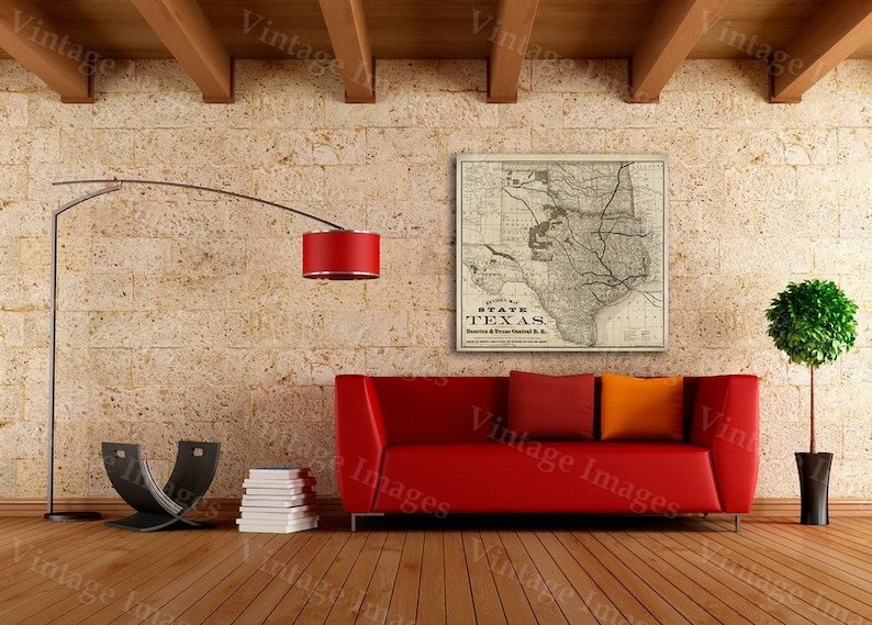 Pode incluir: Um mapa vintage do estado do Texas, impresso em preto e branco, est&aacute; emoldurado e pendurado em uma parede de uma sala de estar. O mapa &eacute; cercado por um sof&aacute; vermelho, um abajur de ch&atilde;o com uma c&uacute;pula vermelha e um piso de madeira.