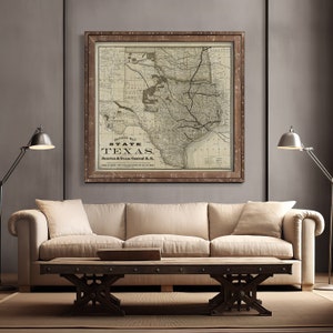 Pode incluir: Um mapa vintage enquadrado do estado do Texas, com o t&iacute;tulo "Revised Map State Texas Houston & Texas Central R.R.". O mapa &eacute; em preto e branco com linhas e texto marrons. A moldura &eacute; de madeira marrom com um acabamento envelhecido.