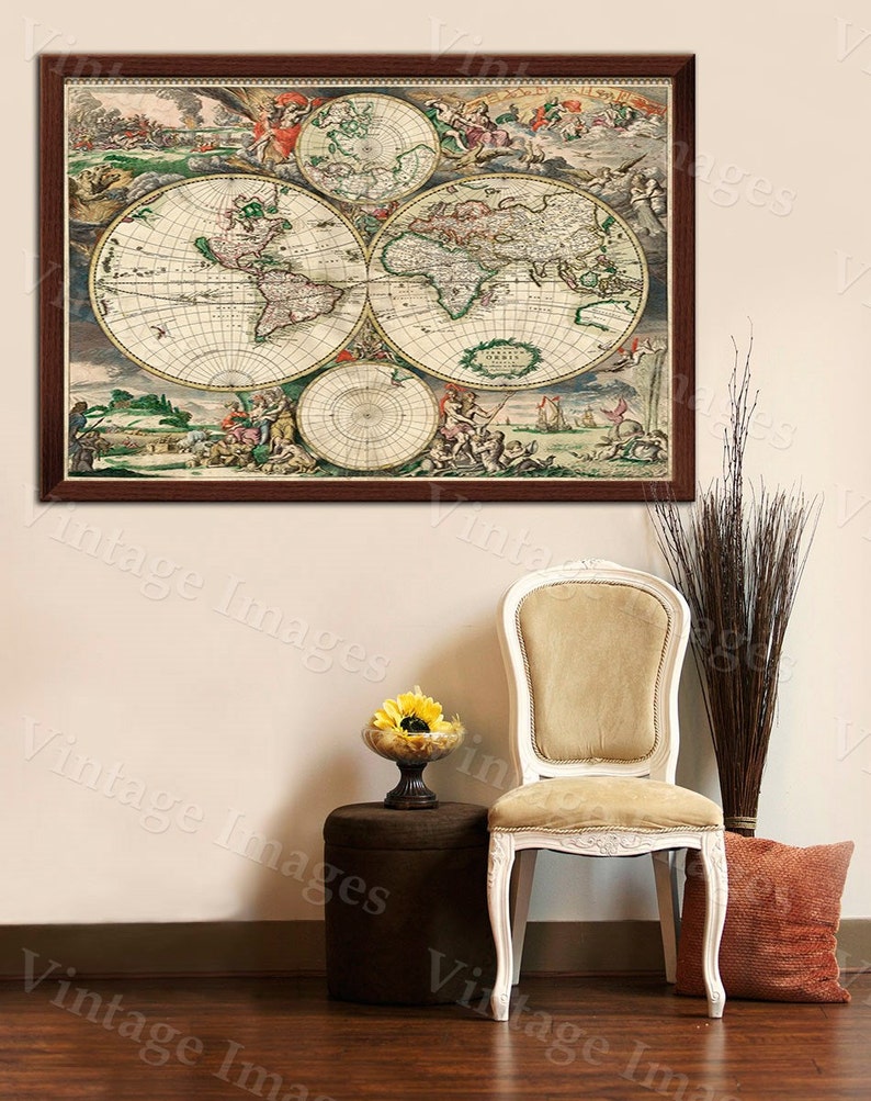Puede incluir: Una impresi&oacute;n vintage de mapa del mundo enmarcada con un marco marr&oacute;n cuelga de una pared blanca sobre una silla blanca con un coj&iacute;n beige. Un peque&ntilde;o taburete marr&oacute;n con un arreglo de flores amarillas se encuentra frente a la silla.