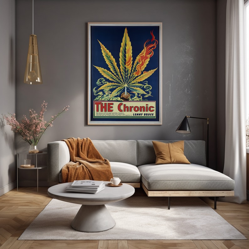 May include: A living room interior with a gray sectional sofa, a gray coffee table, a gold pendant light, and a framed poster with a marijuana leaf and the text "THE Chronic LENNY BRUCE".