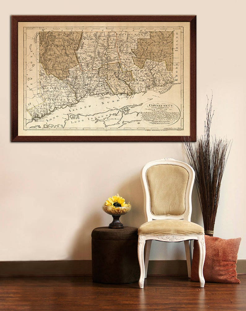 May include: A framed antique map of Connecticut, with the title "Connecticut" in a circle at the bottom right corner. The map is in shades of brown and beige, with a brown frame.