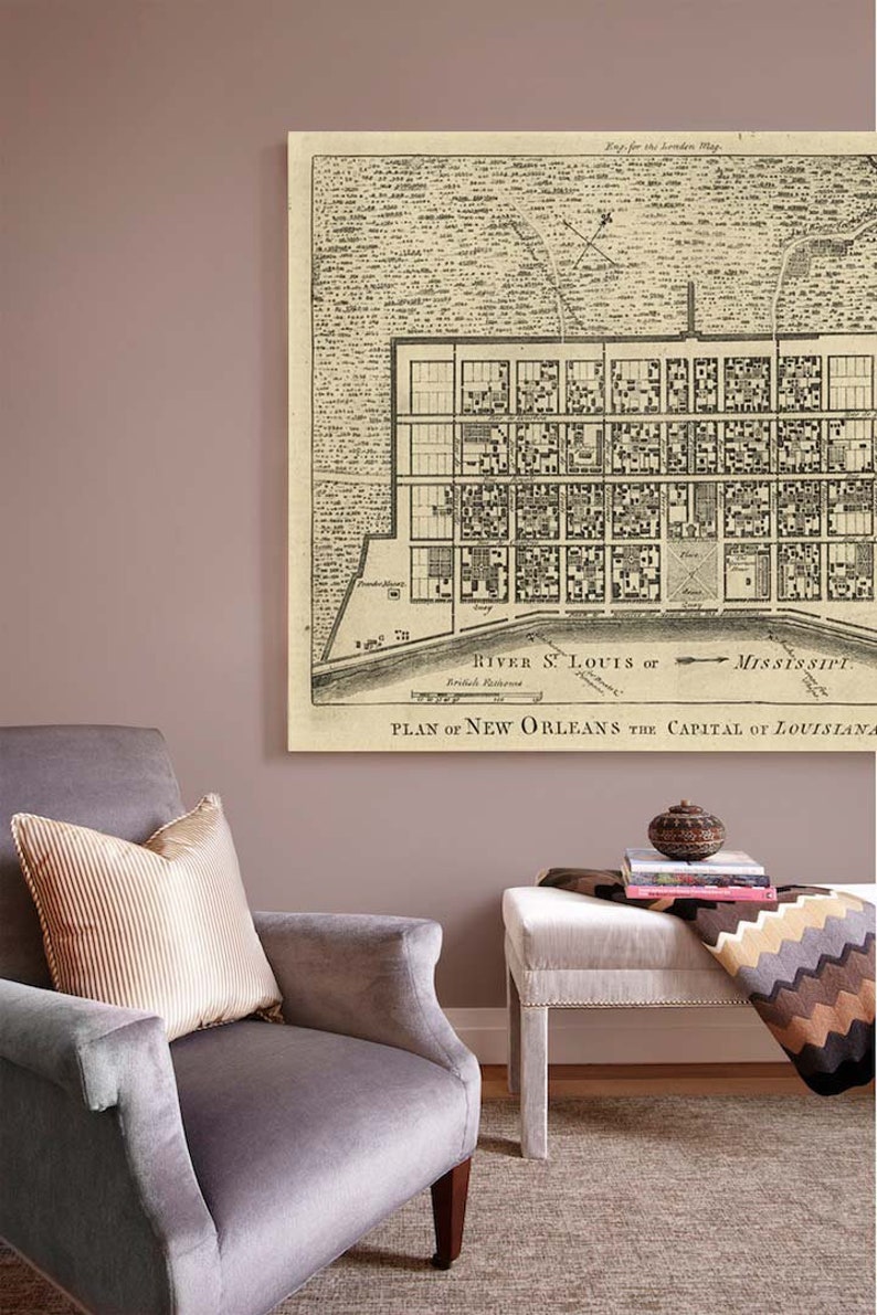May include: A vintage map of New Orleans, Louisiana, printed on canvas and framed. The map shows the city's layout with streets and buildings, and includes the text "PLAN OF NEW ORLEANS THE CAPITAL OF LOUISIANA".