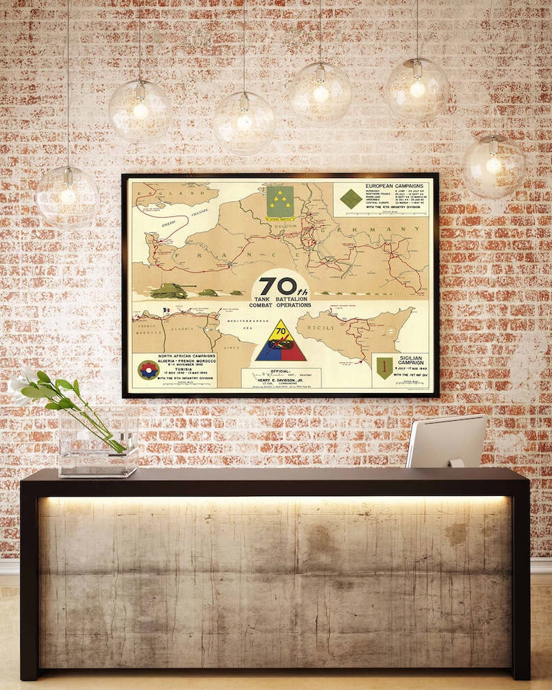 May include: A vintage-style map poster depicting the combat operations of the 70th Tank Battalion during World War II. The map shows the battalion's movements across Europe and North Africa, with key locations and dates marked. The poster features a red, white, and blue triangle with the number "70" in the center, and the text "70th Tank Battalion Combat Operations".